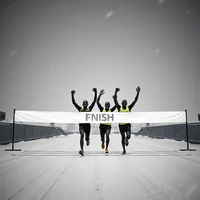 Elite runners in neon kit triumph at rooftop track finish line during blizzard, high-contrast B&W wide shot.